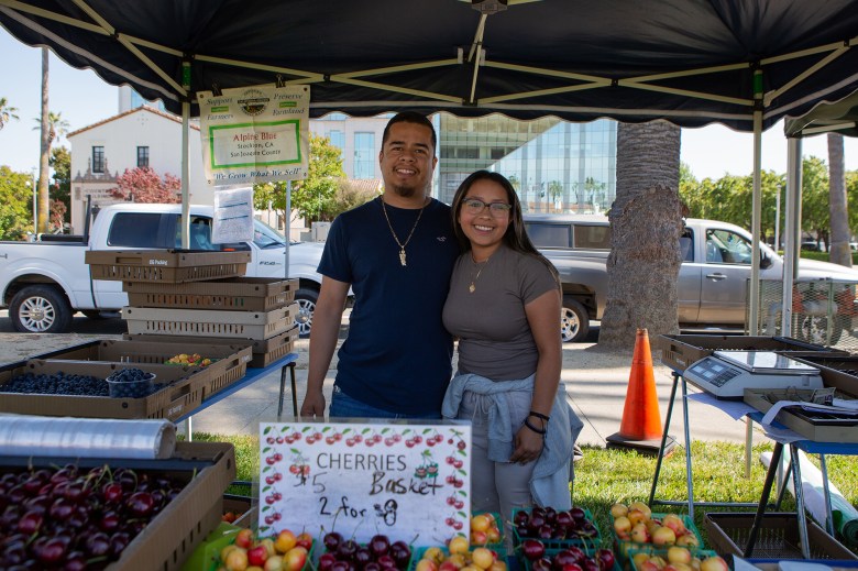 Farmer Salvador Navarro and his daughter Kimberly Navarro at the farmers' market in Fairfield on June 15, 2023. The majority of Navarro's customers use Market Match and other benefit programs to purchase their produce. Photo by Semantha Norris, CalMatters.