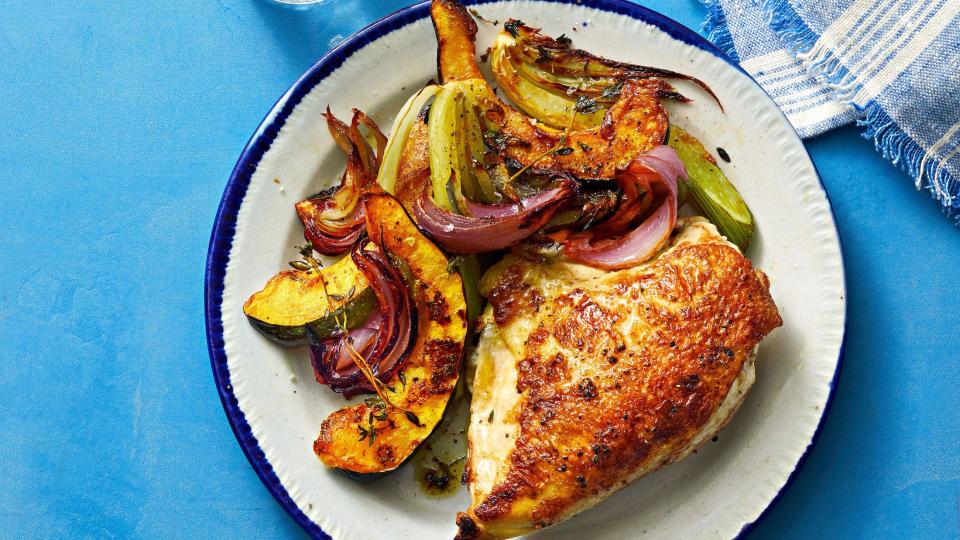 chicken on a plate with a roasted vegetables on the side