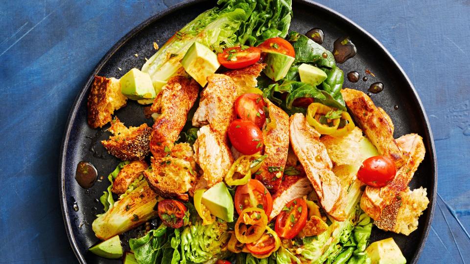 chicken thighs over baby romaine salad with avocado, tomatoes, and croutons