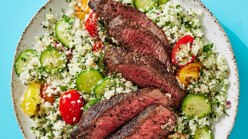 steak over cauliflower tabbouleh with cucumbers and tomatoes