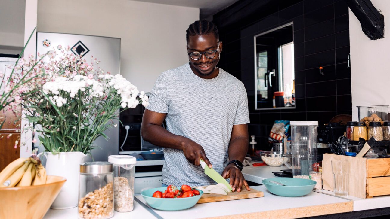 A smiling man cooking in a kitchen.