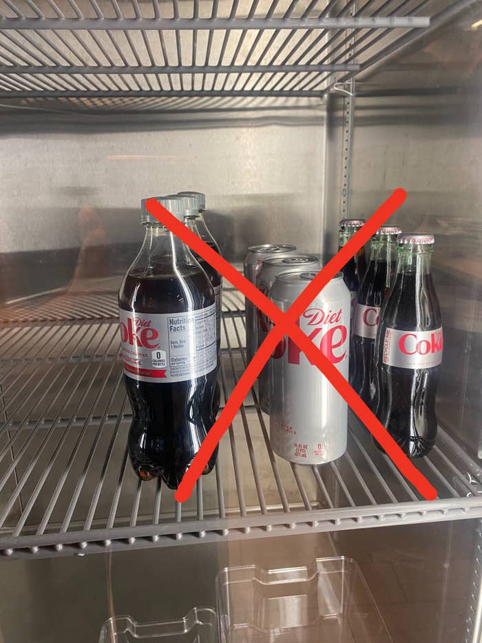 bottles and cans of diet coke in a fridge with an "x" through it