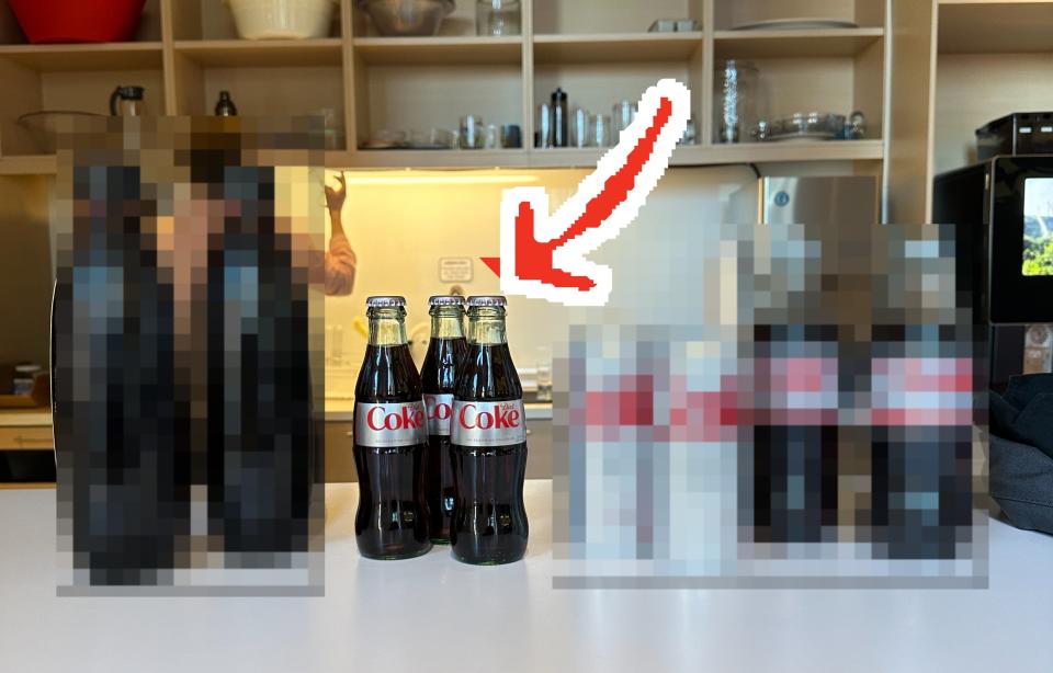 the four different types of diet coke lined up on a table with an arrow pointing to the glass bottle