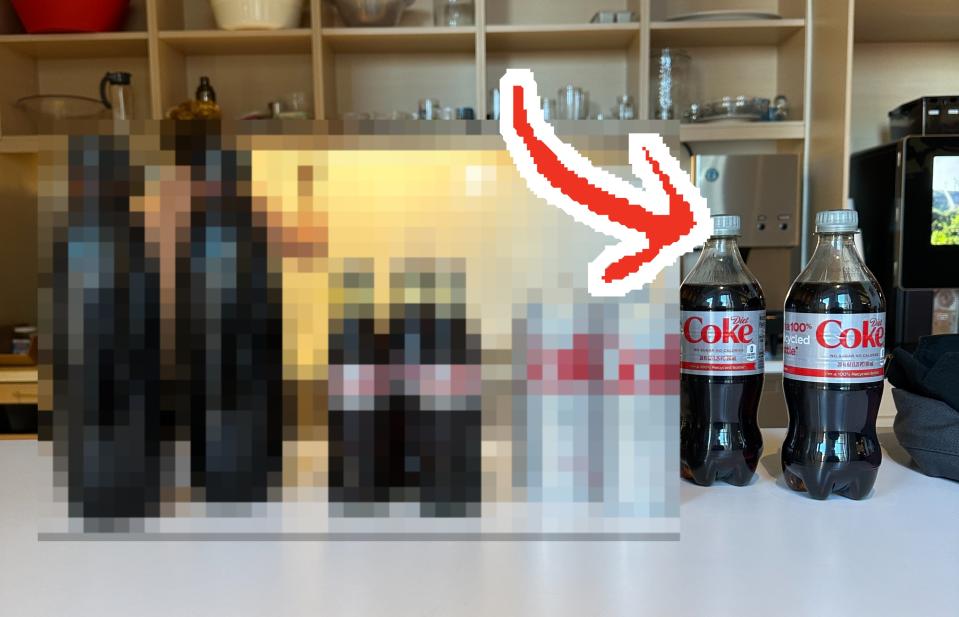 the four different types of diet coke lined up on a table with an arrow pointing to the plastic bottle