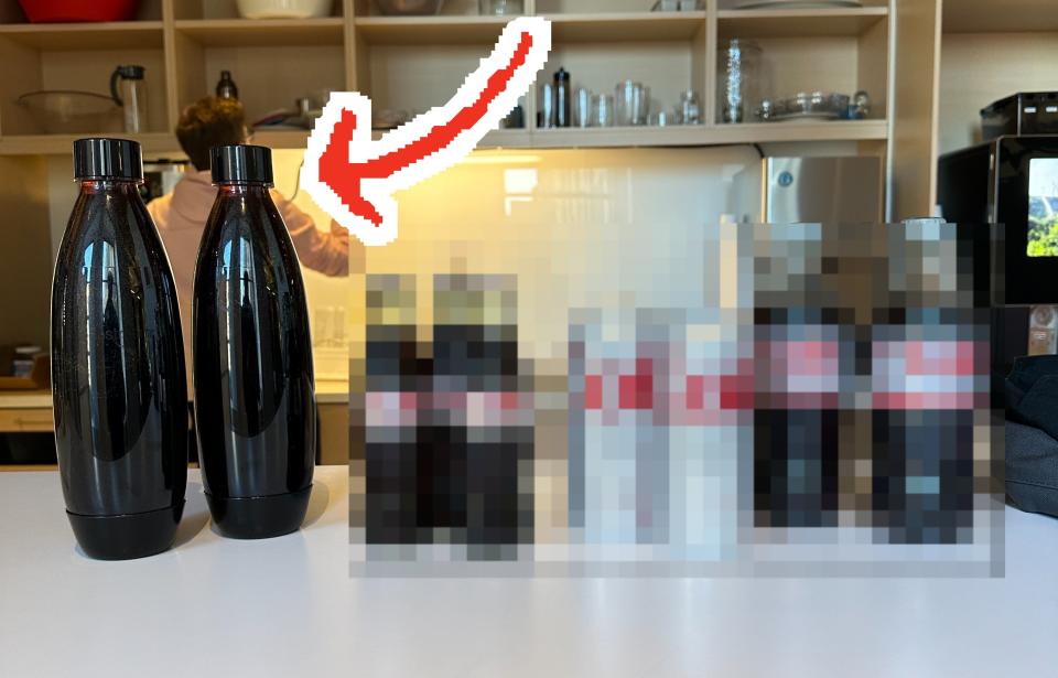 the four different types of diet coke lined up on a table with an arrow pointing to the soda stream bottles