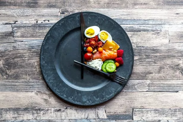 This is an image of plate with food on it and two hands resembling those of a clock