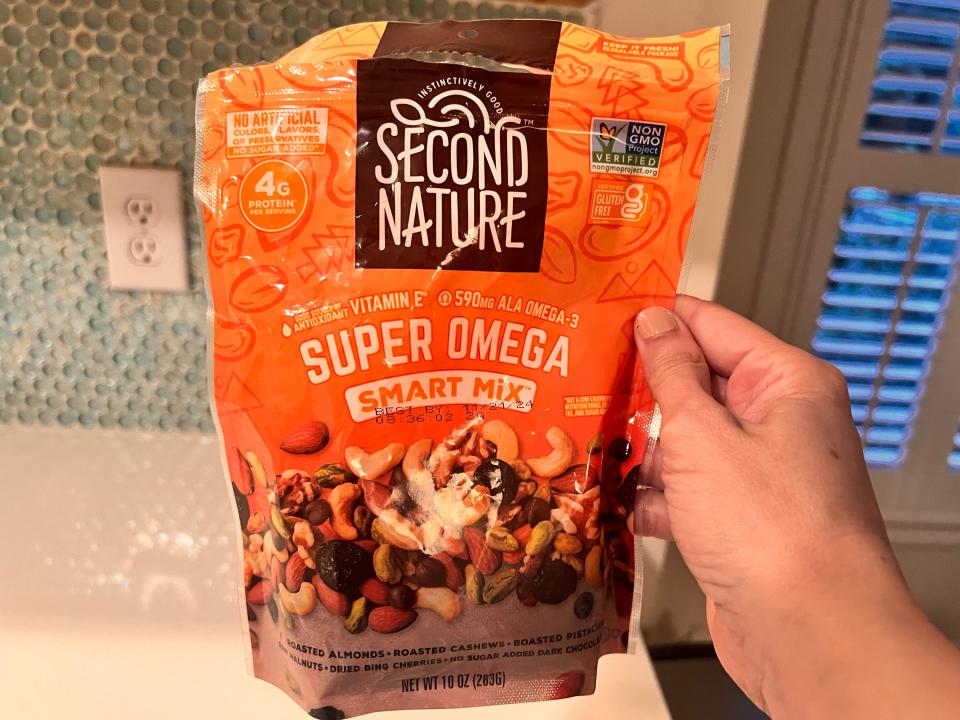 hand holding up a bag of second nature super omega snack mix