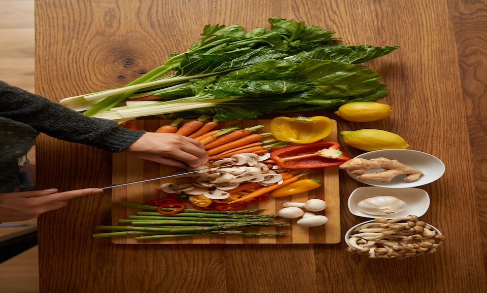 vegetables being cut on wooden board