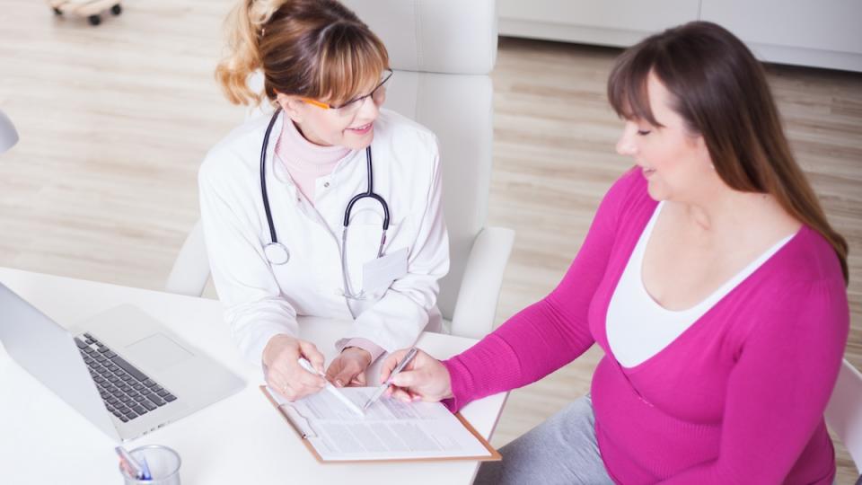 Woman undergoes an examination at dietitian-nutritionist's office . They looking results and talk about dieting and healthy eating