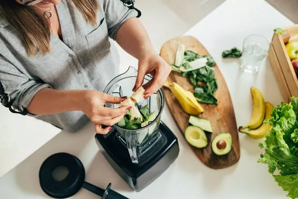 Person making green smoothie