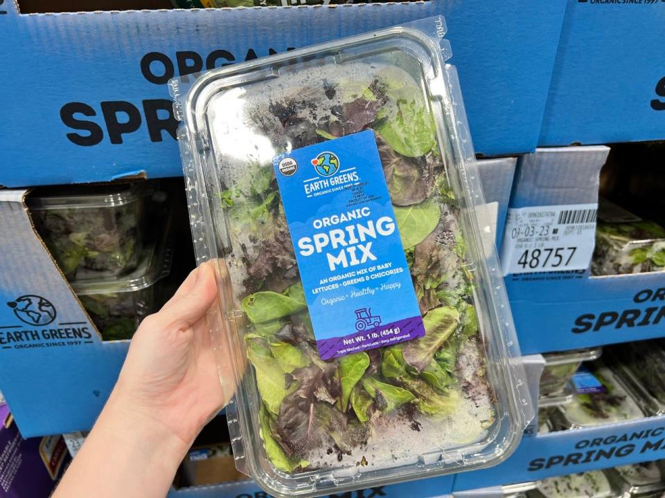 Organic spring mix in clamshell container at Costco in author's hand