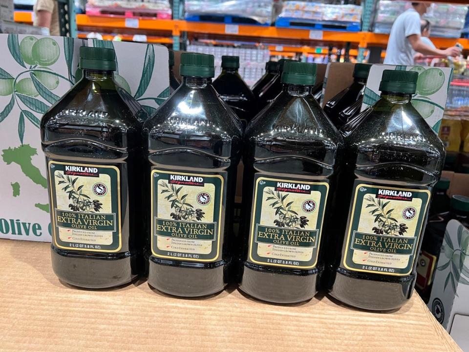 Bottles of Kirkland extra-virgin olive oil on cardboard box in Costco